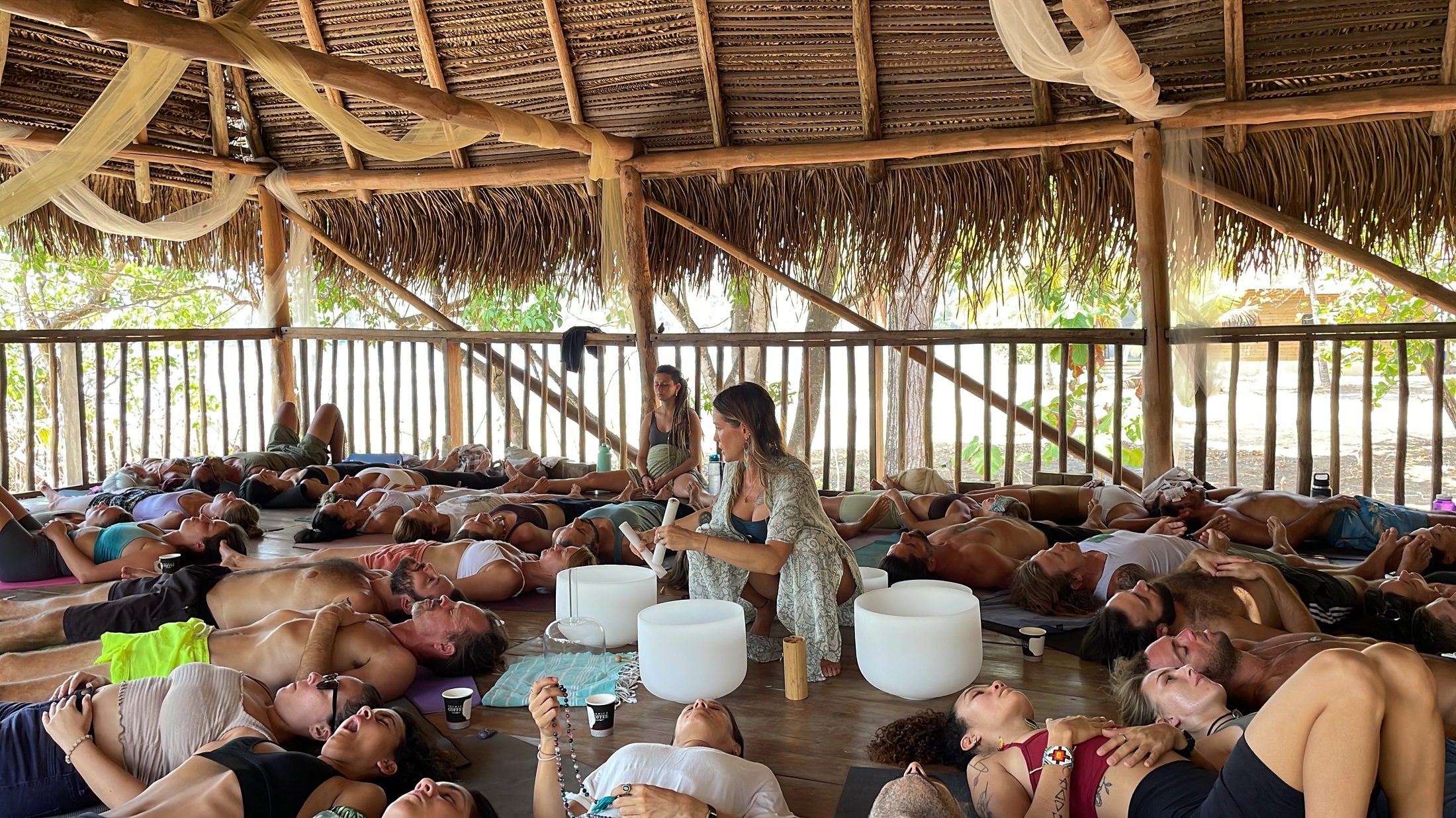 Kate leading a sound healing ceremony with crystal bowls in a palapa